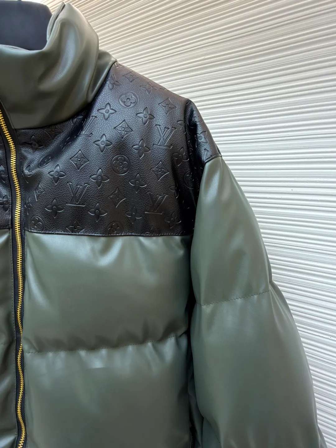 LOUIS VUITTON embossed splicing down jacket ●Original version: purchased and developed at 39599 ●Item number: 1682246-D35 ●Fabric: cotton fabric ●Technology: embossed production ●Version: fitted version ●Weight: about 1455 grams ●Size: 46-48-50-52 ●Description: This Louis Vuitton color-blocked down jacket is made with high-end craftsmanship. The main body of the jacket is made of high-grade artificial leather with a matte texture. It has been treated with water-repellent treatment and softened and polished multiple times. It has a delicate touch and is wrinkle-resistant. The shoulders and collar are spliced with black leather embossed with the classic Monogram pattern. The embossing process is hot-pressed with a precise temperature-controlled mold. The pattern has a uniform depth and a three-dimensional outline, restoring the brand's iconic elements. The filling layer adopts the golden ratio of 90% white goose down and 10% feathers. It is manually filled through the divided down filling process. The amount of down in each grid is precisely controlled to ensure that the warmth and fluffiness are evenly distributed. The metal zipper is made of custom-made brass and has been treated with gold-plated anti-oxidation treatment. The zipper teeth have high tightness and smooth pulling. The neckline is cut with a stand-up collar, which is fixed with three-dimensional stitching technology. The overall stitching adopts double-needle overlocking technology. The stitching is fine and flat, taking into account durability and light luxury texture. The details show the brand's ingenious craftsmanship. The overall wiring is straight and delicate, the fabric is comfortable and soft, and the color is consistent without color difference. It can be matched with the same style to create a fashionable look and control various occasions. Customized accessories, complete with three standards, same style for men and women!